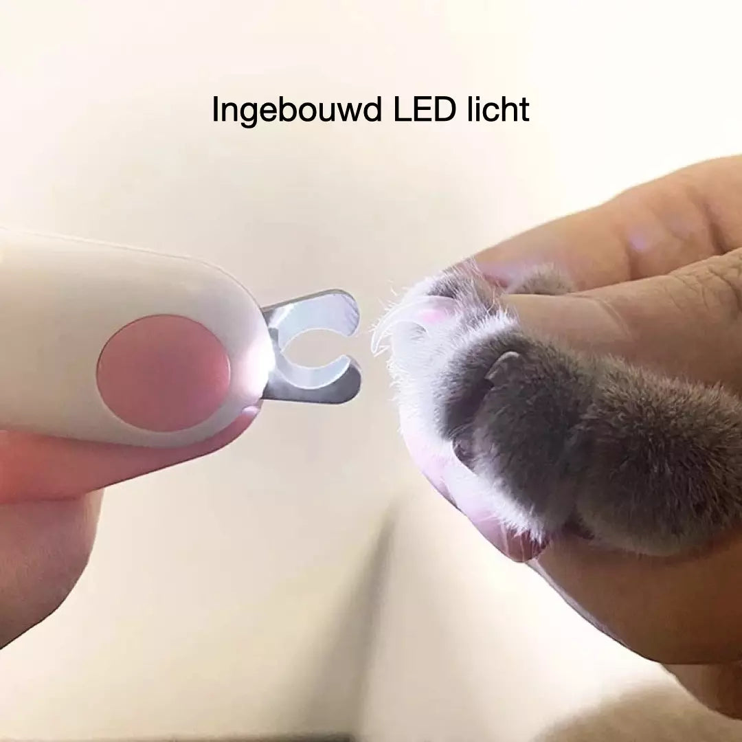 De nagelknipper voor huisdieren met ingebouwd LED licht wordt gebruikt bij een kat.  Het LED licht staat aan.