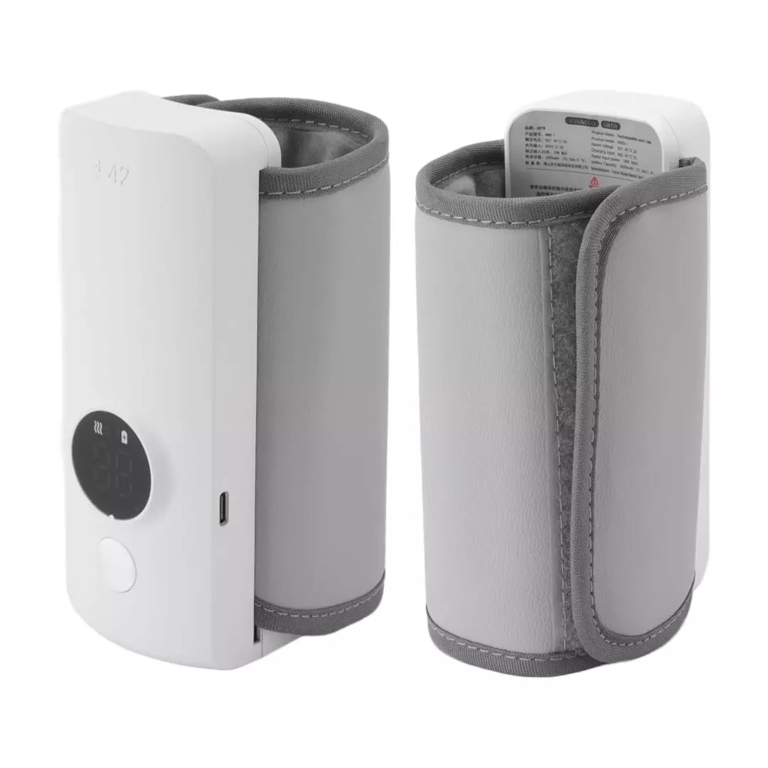 De oplaadbare flessenwarmer in de kleur wit. De oplaadbare flessenwarmer staat aan en er staat een gevuld flesje naast.